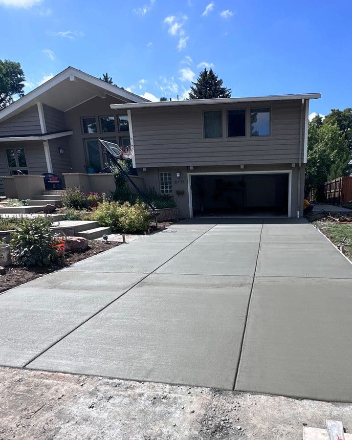 A new concrete driveway with a broom finish and cut joints.
